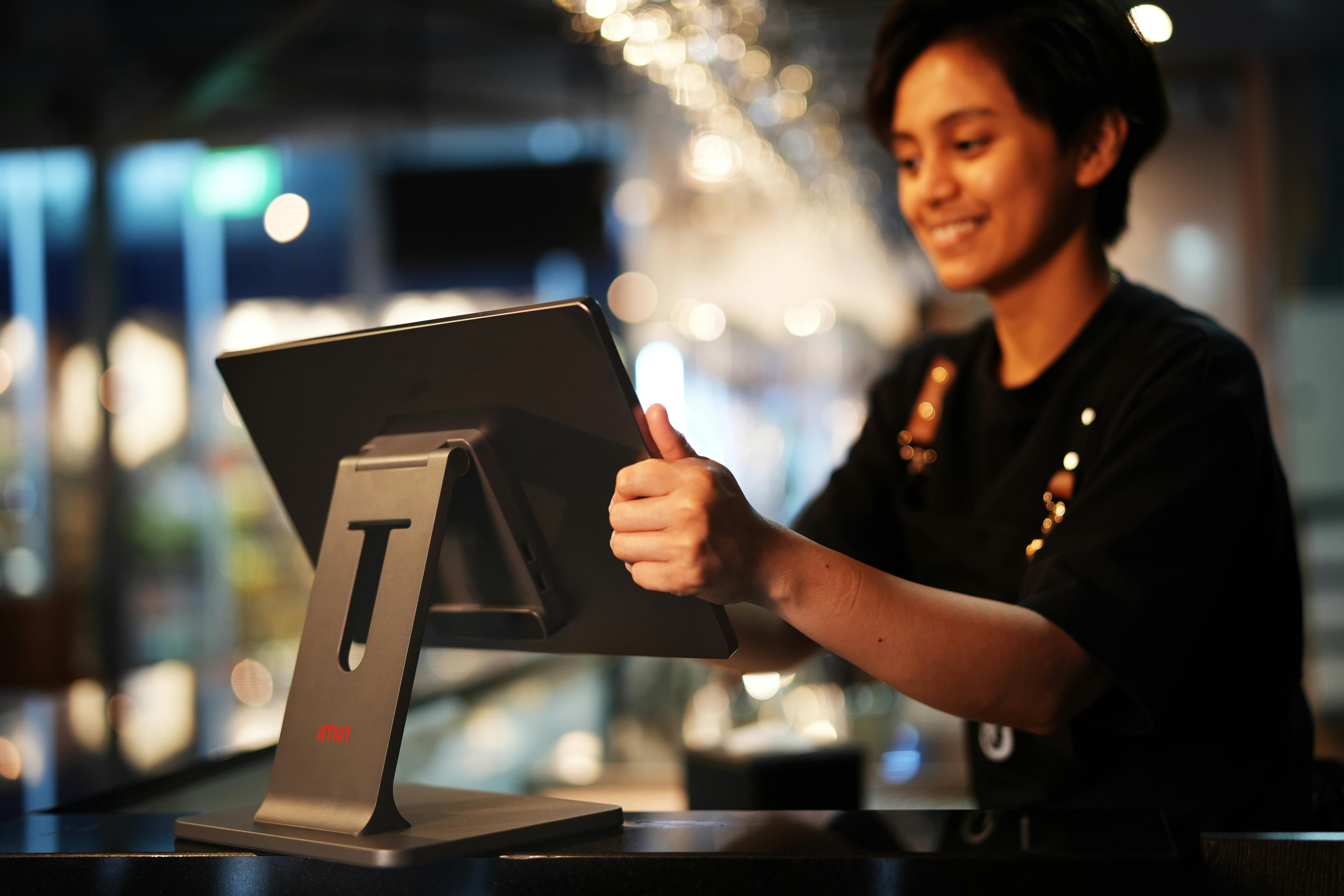 Restaurant cashier using a touchscreen point-of-sale terminal